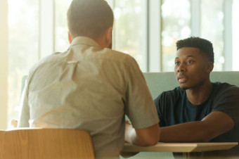 Photo of two people sat facing each other at a table