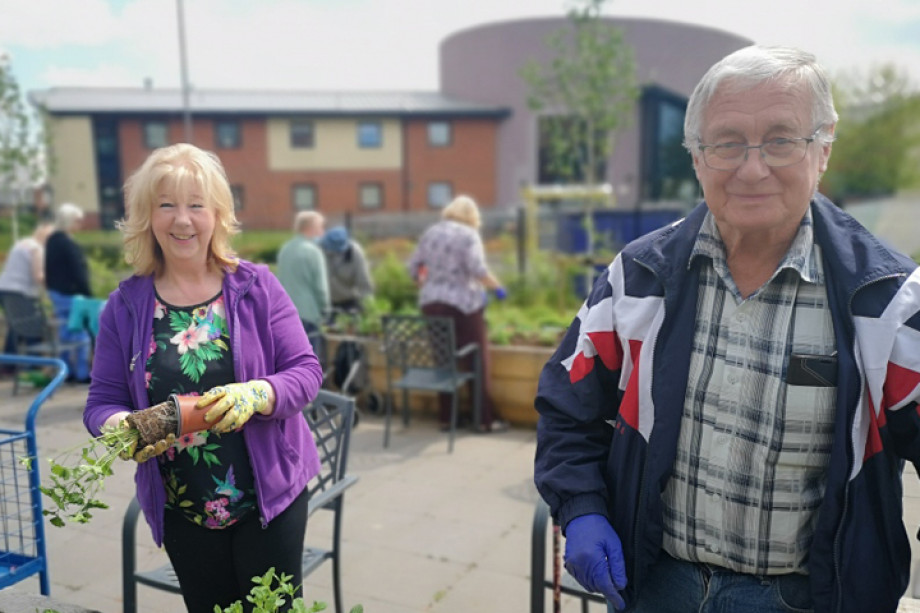 Photo of two people stood in a communal garden